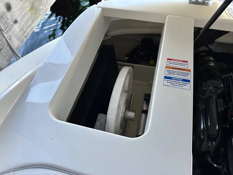 Slide: The Image of 2022 Sea Ray 230SPX engine compartment with safety labels and components visible. - 12