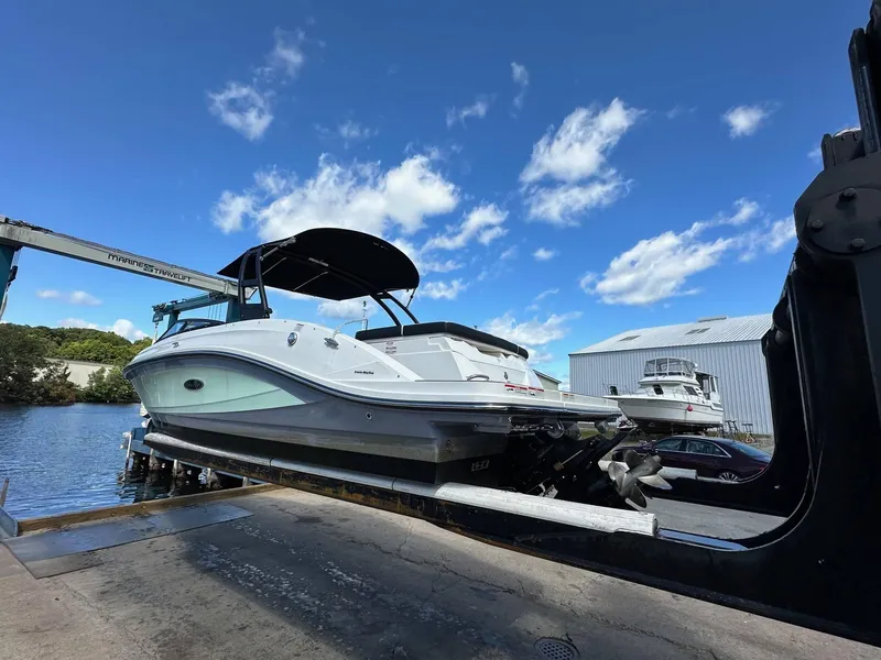 Slide: The Image of 2022 Sea Ray 230SPX boat on lift at marina, clear sky background. - 4