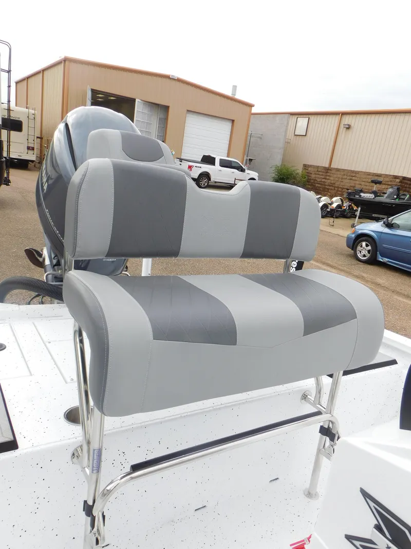 Slide: The Image of 2025 Xpress H21 Bay boat with gray and white seating in a marina setting. - 11