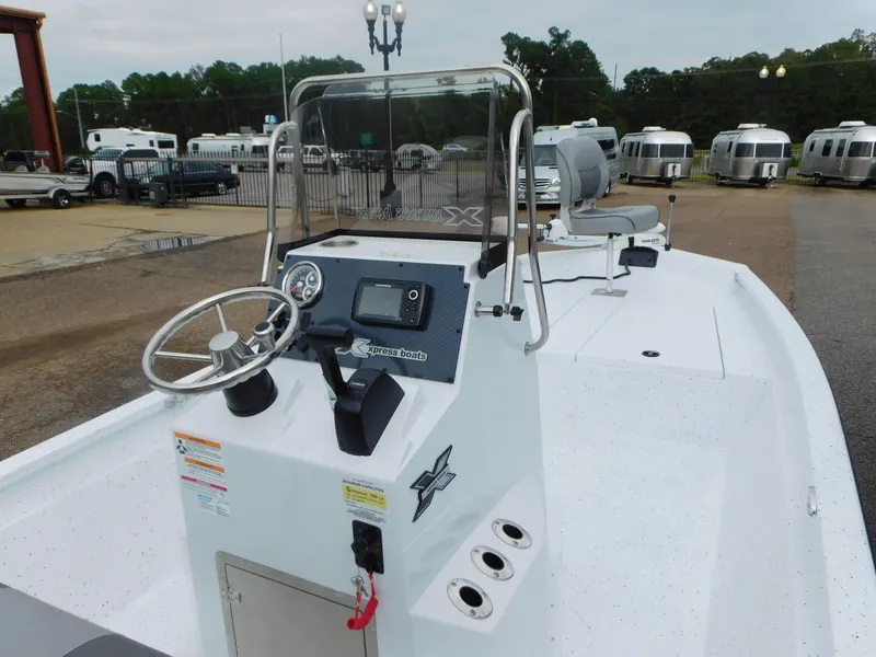 Slide: The Image of 2025 Xpress H21 Bay boat with modern console and steering wheel, parked outdoors. - 4