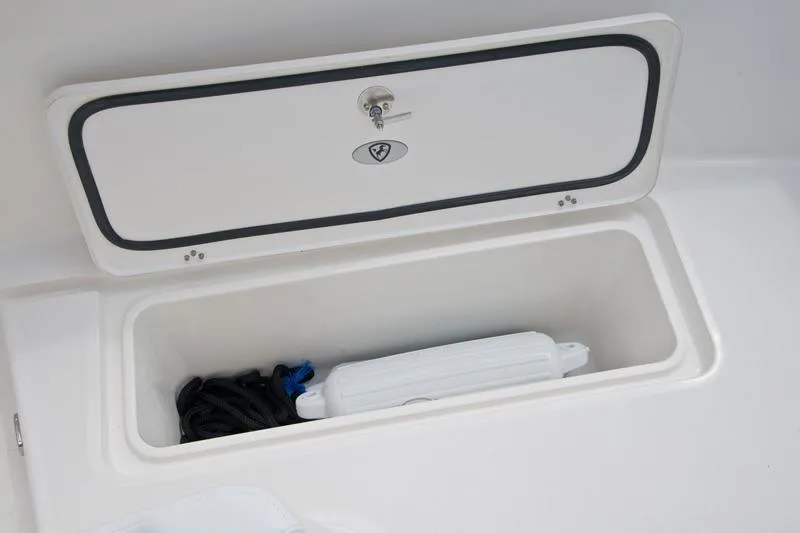 Slide: The Image of Storage compartment on 2015 Century 3200 Center Console boat, containing a rope and fender. - 14