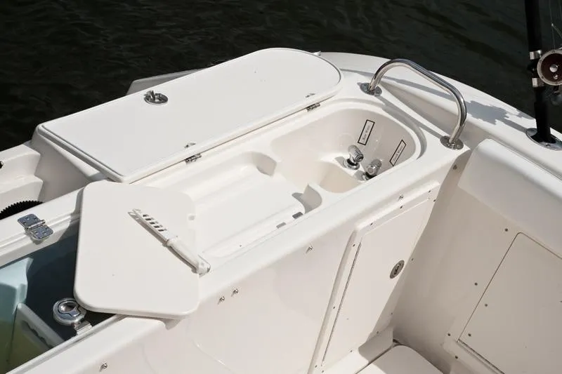 Slide: The Image of 2015 Century 3200 Center Console boat interior with storage compartments and sink. - 16