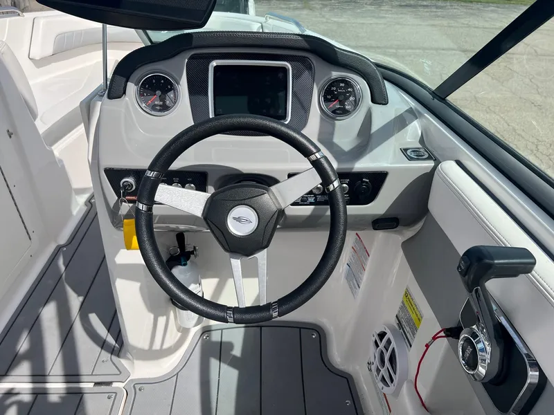 Slide: The Image of 2021 Chaparral 21 Surf boat dashboard with steering wheel and controls. - 6