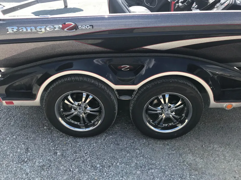 Slide: The Image of 2017 Ranger Z520 Comanche boat trailer with dual chrome wheels on gravel. - 19