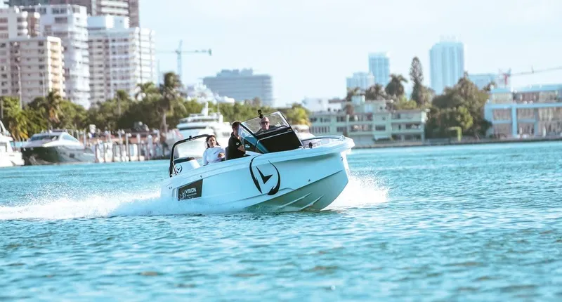 Slide: The Image of 2021 Axopar Spyder 22 speeding on water with city skyline in background. - 3