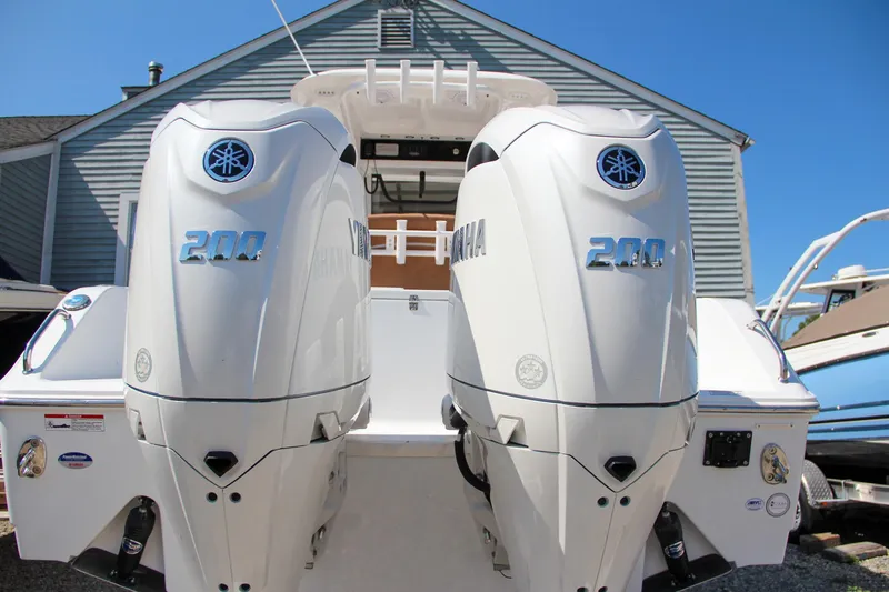 Slide: The Image of 2025 Sea Hunt Gamefish 25 with dual Yamaha 200 engines, docked near a house. - 11