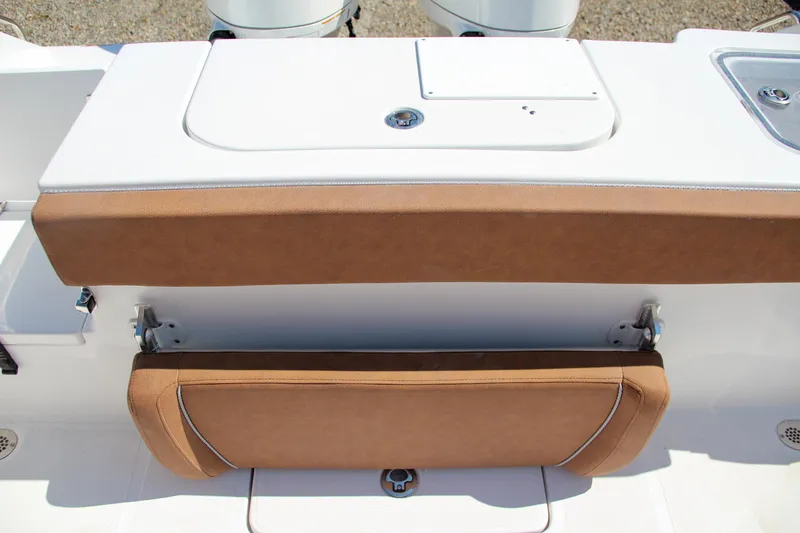 Slide: The Image of 2025 Sea Hunt Gamefish 25 boat seating and storage area, featuring tan upholstery. - 17