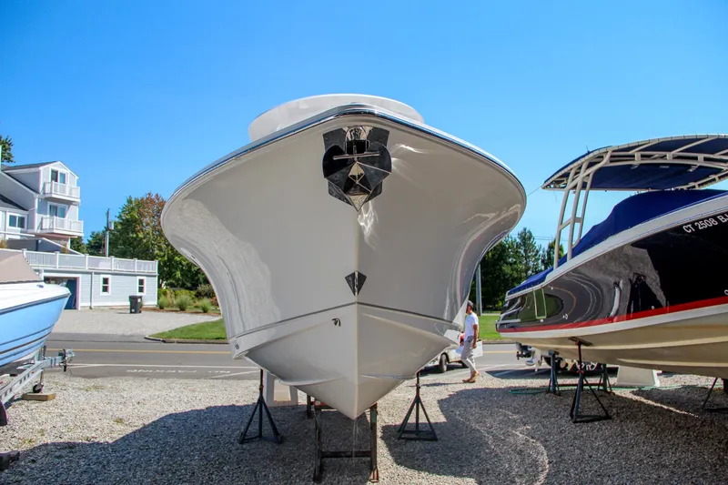 Slide: The Image of 2025 Sea Hunt Gamefish 25 boat displayed on gravel lot. - 2