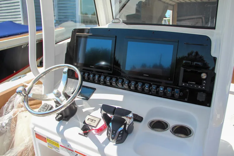 Slide: The Image of 2025 Sea Hunt Gamefish 25 boat dashboard with dual screens and steering wheel. - 31