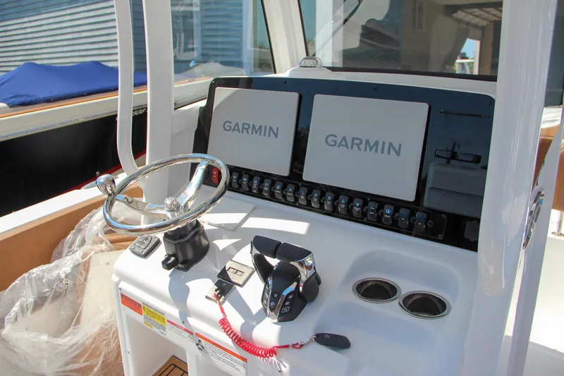 Slide: The Image of 2025 Sea Hunt Gamefish 25 dashboard with dual Garmin displays and steering wheel. - 5