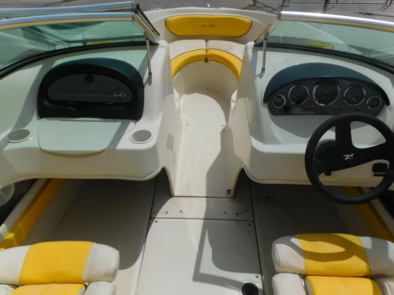 Slide: The Image of 2006 Sea Ray 205 Sport boat interior with yellow and white seating, dashboard, and steering wheel. - 10