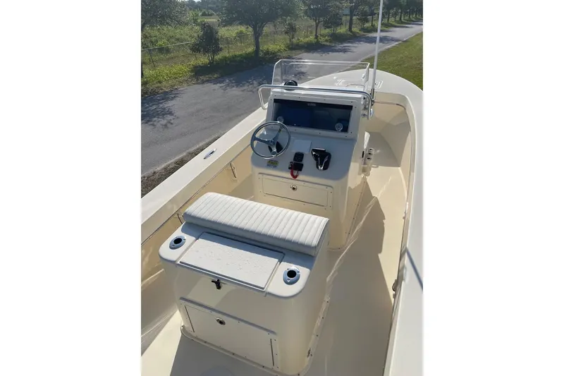 Slide: The Image of 2026 Jones Brothers 20 Cape Fisherman boat with cushioned seating and console, under clear blue sky. - 15