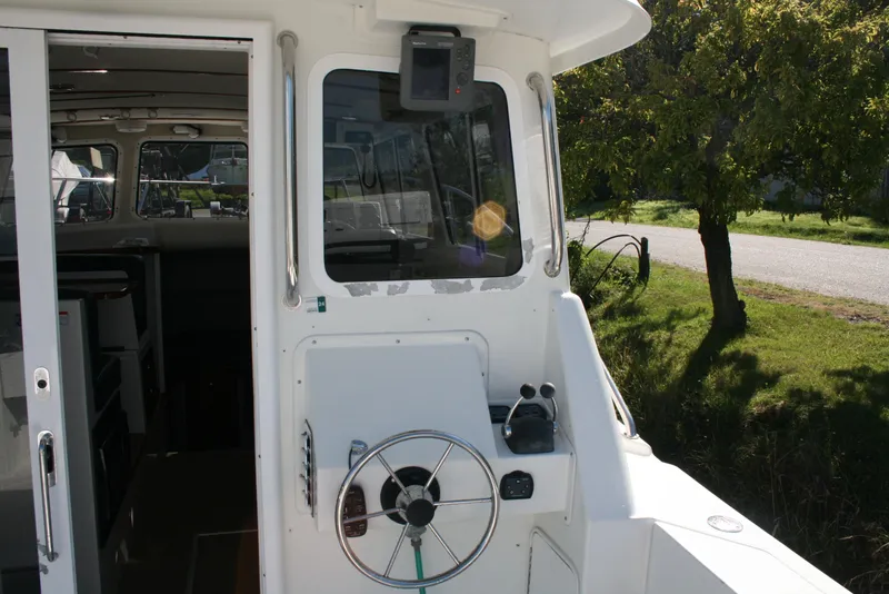 Slide: The Image of 2005 Ocean Sport Roamer 30' #9 boat helm with steering wheel and controls. - 12