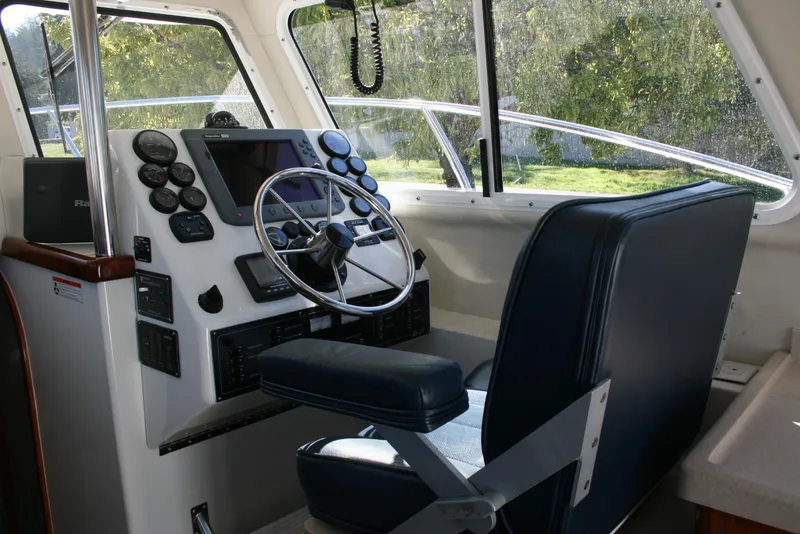 Slide: The Image of Interior helm of 2005 Ocean Sport Roamer 30' boat, featuring steering wheel and control panel. - 5