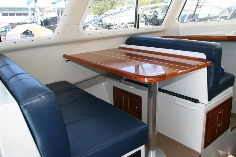 Slide: The Image of Interior of 2005 Ocean Sport Roamer 30' #9 with blue seating and wooden table. - 6