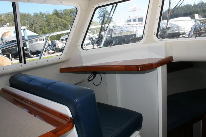 Slide: The Image of Interior of 2005 Ocean Sport Roamer 30' #9 boat with blue seating and wooden accents. - 7