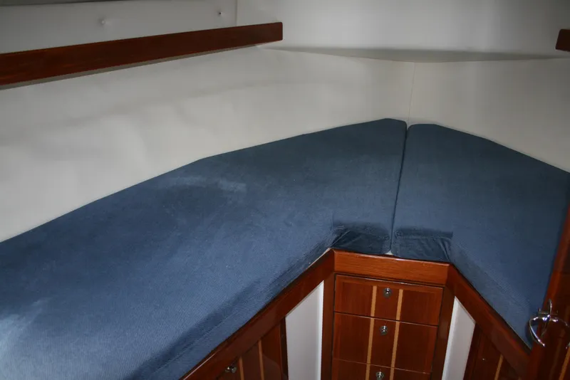 Slide: The Image of Interior cabin of 2005 Ocean Sport Roamer 30' with blue cushions and wooden storage. - 9