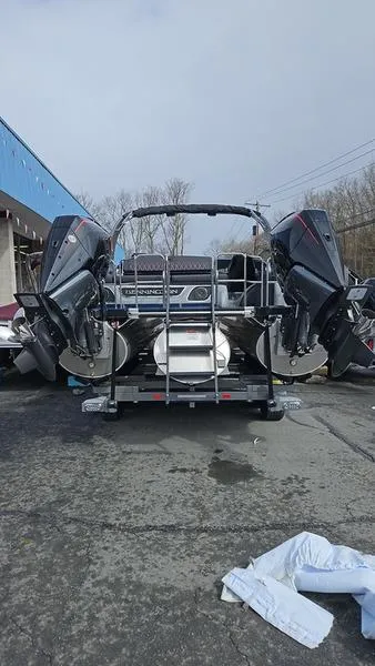 Slide: The Image of 2024 Bennington QX 27 QXSBWA X2 Swingback pontoon boat with dual engines, parked outdoors. - 4