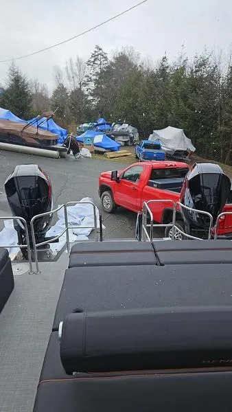 Slide: The Image of 2024 Bennington QX 27 QXSBWA X2 Swingback at marina with boats and red truck. - 6