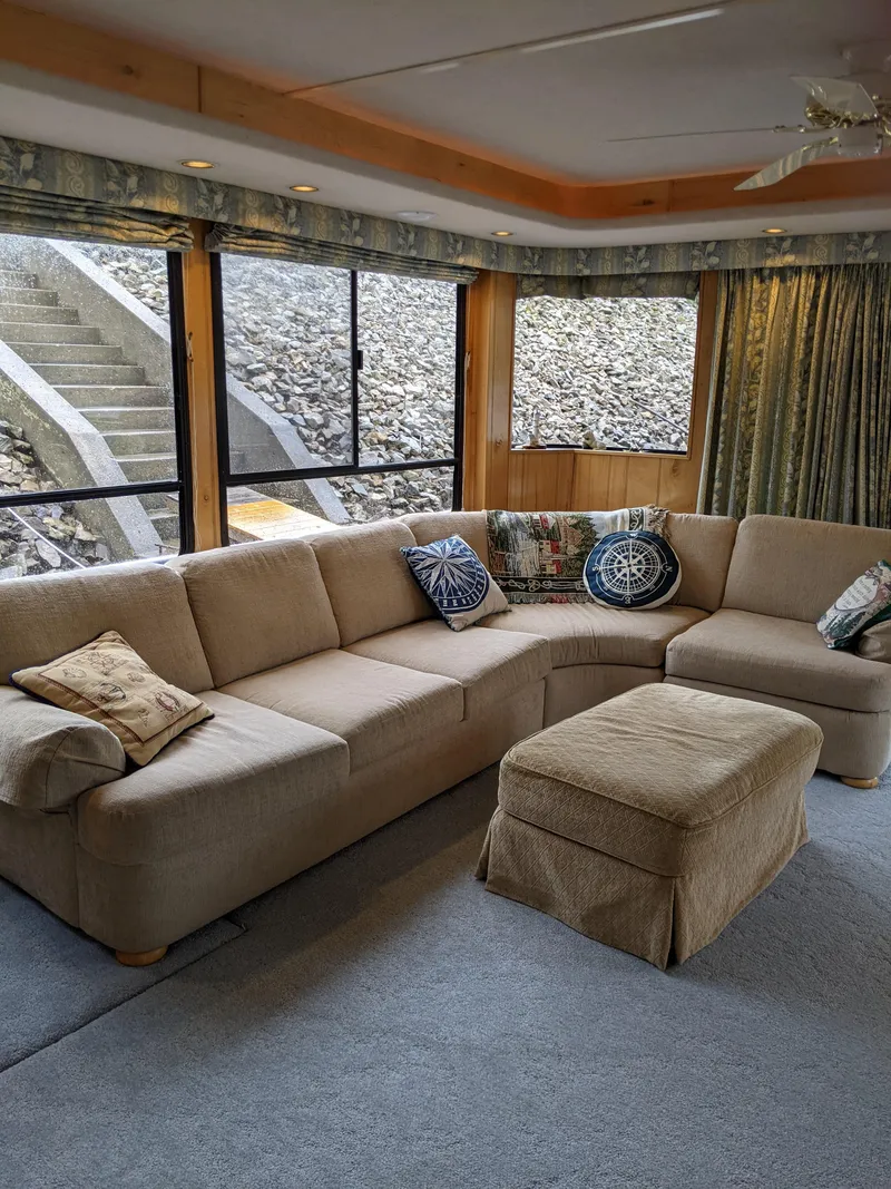 Slide: The Image of Cozy living area in 1999 Sumerset 16x78 houseboat with beige sectional sofa and ottoman. - 10