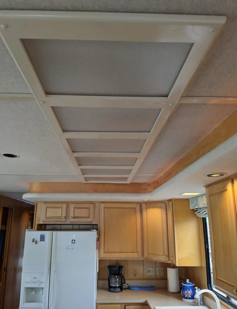 Slide: The Image of 1999 Sumerset 16x78 kitchen interior with wooden cabinets and white appliances. - 16