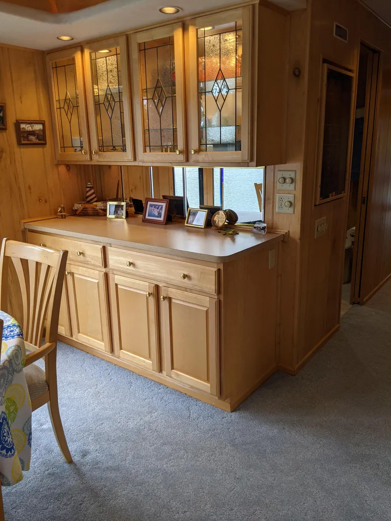 Slide: The Image of 1999 Sumerset 16x78 interior with wooden cabinets and decorative glass doors. - 18