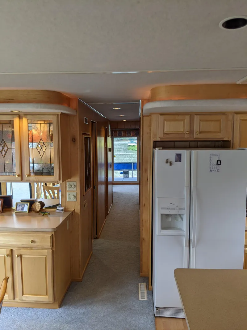 Slide: The Image of Interior of a 1999 Sumerset 16x78 houseboat with wooden cabinetry and white appliances. - 20
