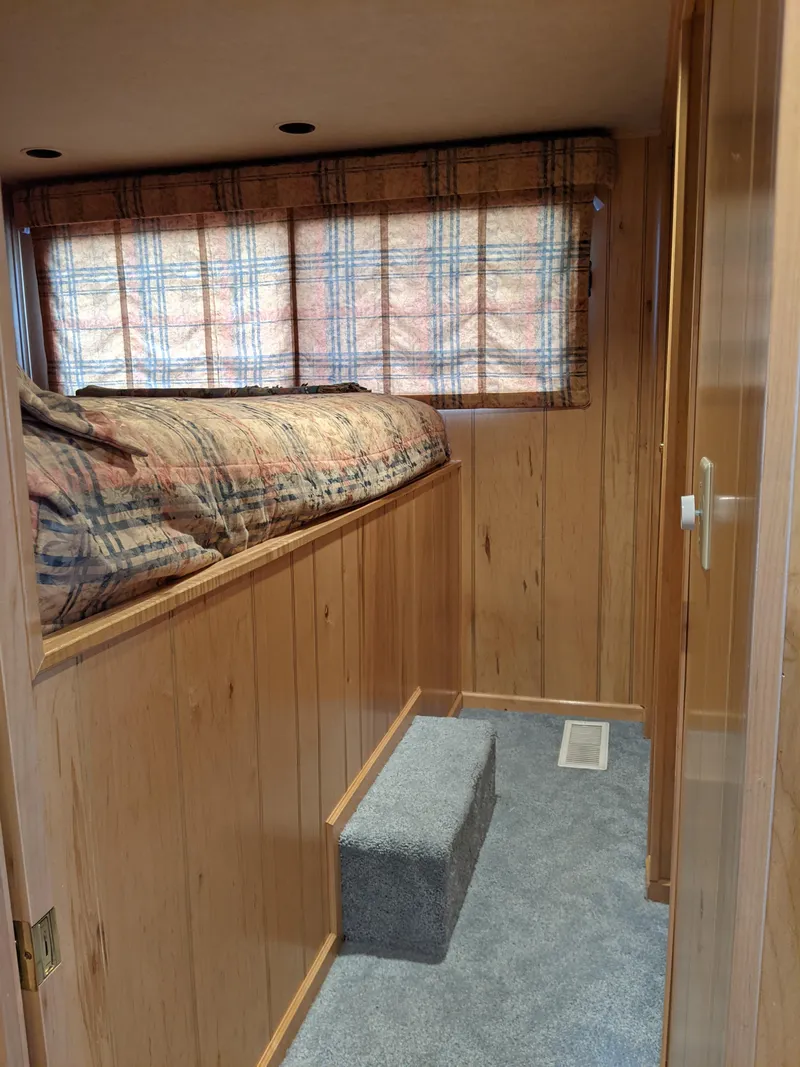 Slide: The Image of Cozy bedroom in 1999 Sumerset 16x78 houseboat with wood paneling and plaid curtains. - 23