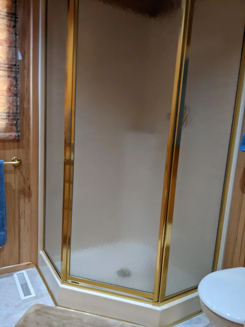 Slide: The Image of 1999 Sumerset 16x78 shower with gold trim in a wooden bathroom. - 25