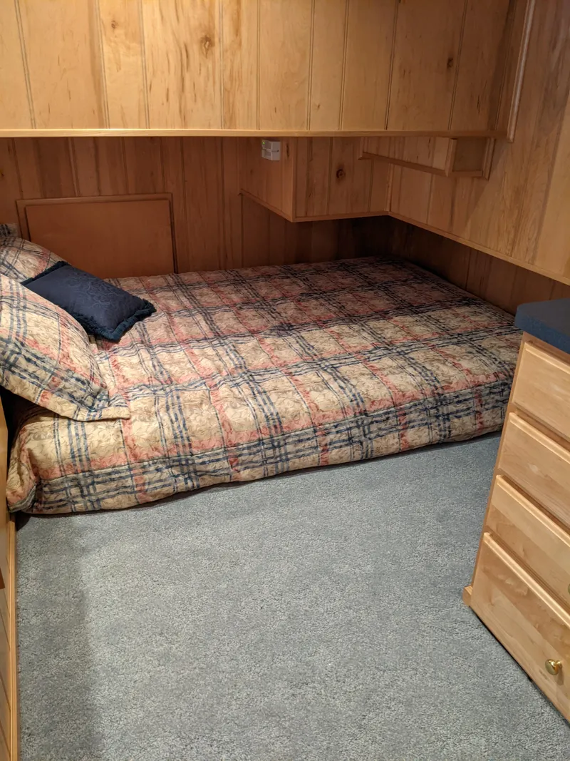 Slide: The Image of Cozy bedroom in 1999 Sumerset 16x78 houseboat with wood paneling and plaid bedding. - 27