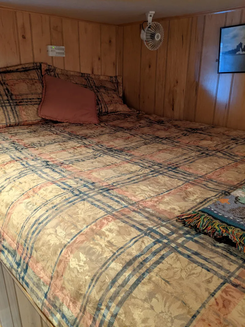Slide: The Image of Cozy bedroom in 1999 Sumerset 16x78 houseboat with plaid bedding and wood paneling. - 28