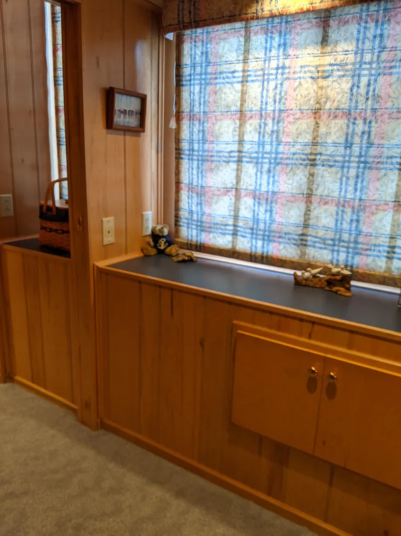 Slide: The Image of Wood-paneled interior of a 1999 Sumerset 16x78 houseboat with plaid curtains and decorative items. - 29