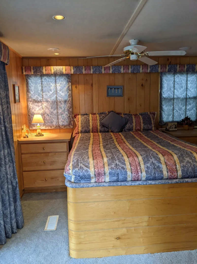 Slide: The Image of Cozy bedroom in 1999 Sumerset 16x78 houseboat with wood paneling and colorful bedding. - 35