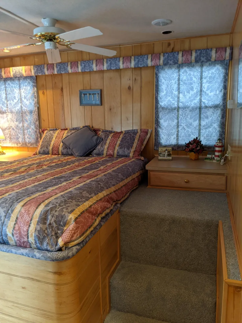 Slide: The Image of Cozy bedroom in 1999 Sumerset 16x78 houseboat with wood paneling and colorful bedding. - 38