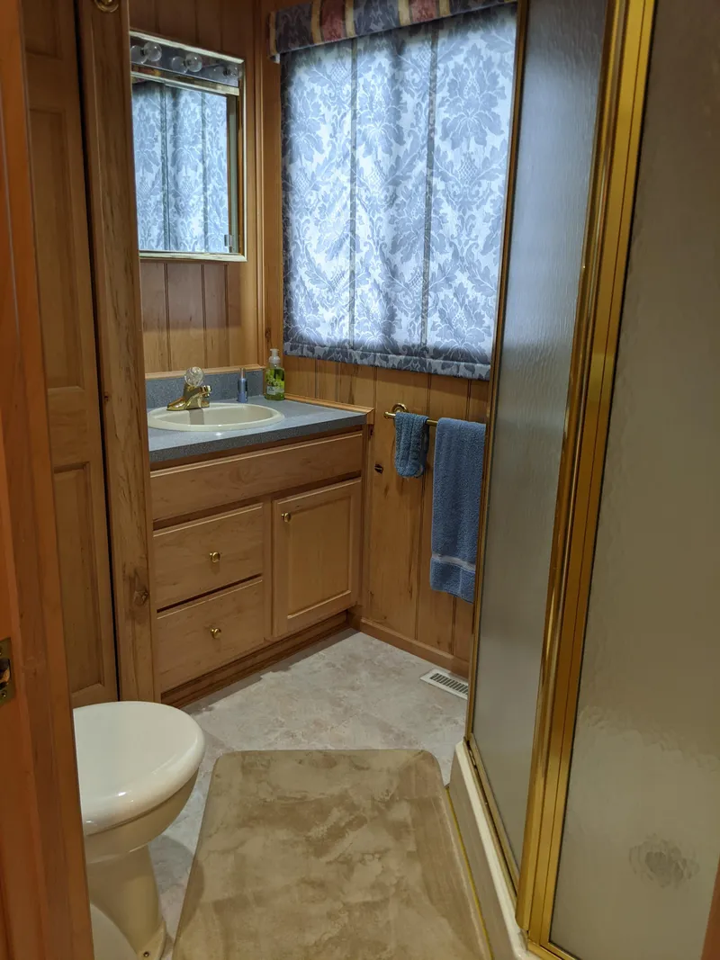 Slide: The Image of 1999 Sumerset 16x78 houseboat bathroom with wood paneling, shower, and vanity. - 39