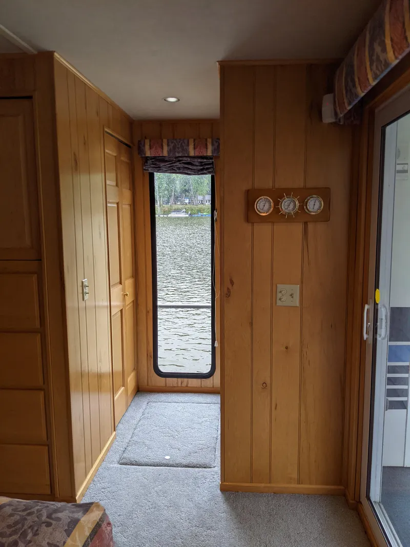 Slide: The Image of Interior of 1999 Sumerset 16x78 houseboat with wood paneling and river view. - 43