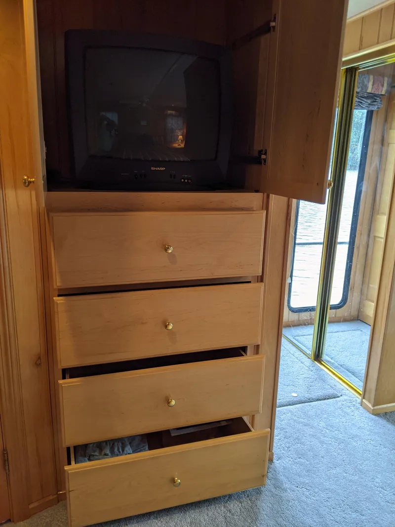 Slide: The Image of Wooden cabinet with TV and drawers in a 1999 Sumerset 16x78 houseboat. - 47