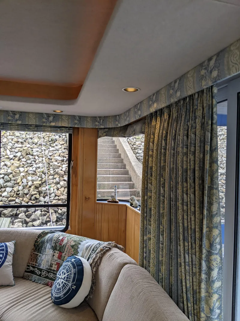 Slide: The Image of Interior of 1999 Sumerset 16x78 houseboat with cozy seating and decorative pillows. - 8