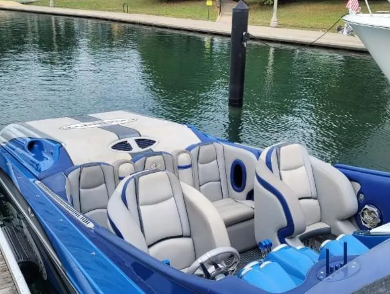 Slide: The Image of 2009 Cigarette 46' Rider XP boat with blue and gray seating docked by the water. - 3