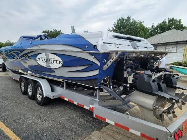 Slide: The Image of 2009 Cigarette 46' Rider XP boat on trailer, blue and silver design. - 7