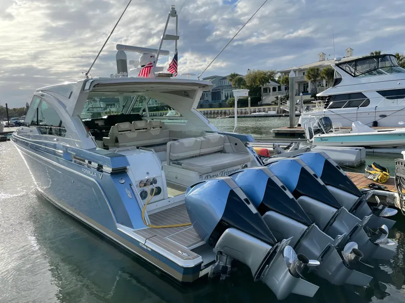 Slide: The Image of 2019 Formula 400 SSC boat docked, featuring four powerful outboard engines and a sleek design. - 2