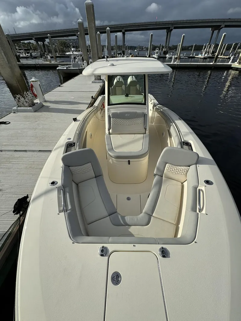 Slide: The Image of 2021 Scout 305 LXF boat docked at marina, featuring spacious seating and sleek design. - 1