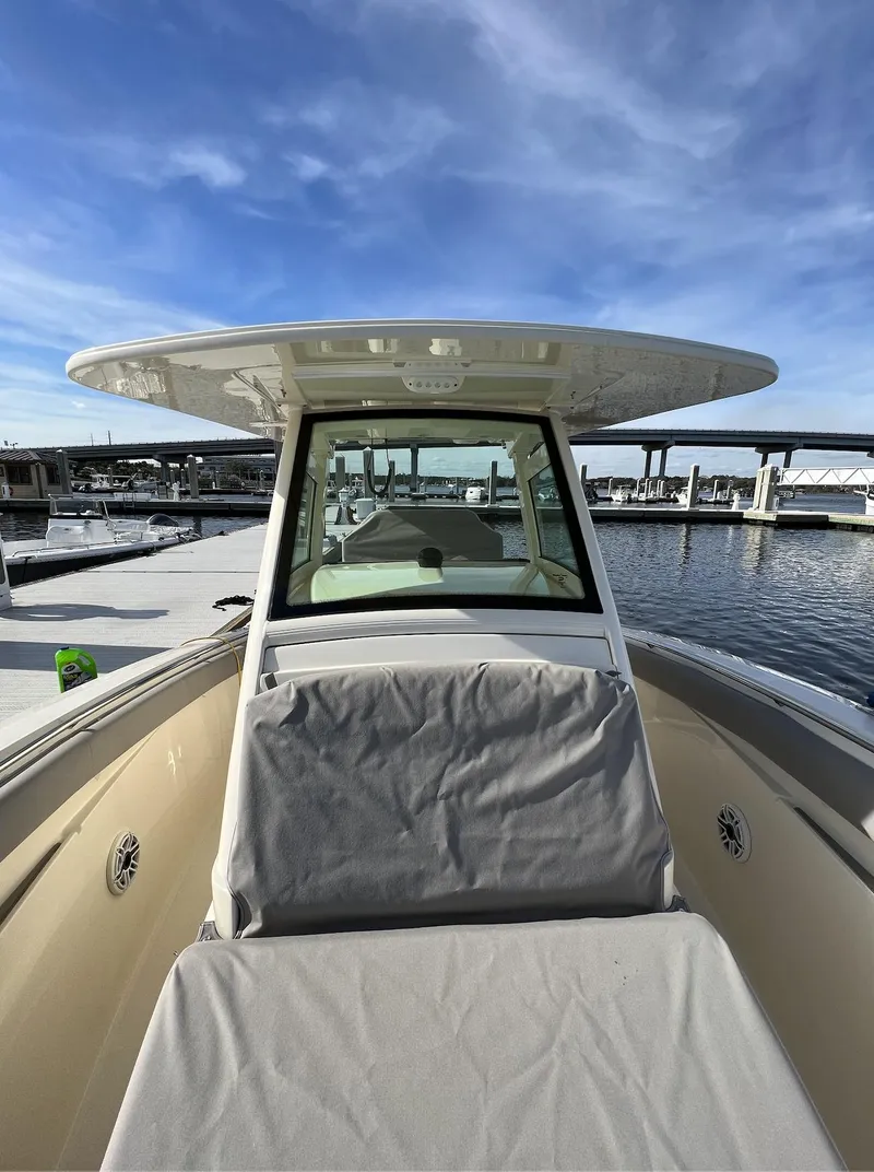 Slide: The Image of 2021 Scout 305 LXF boat at marina, clear sky, modern design. - 2