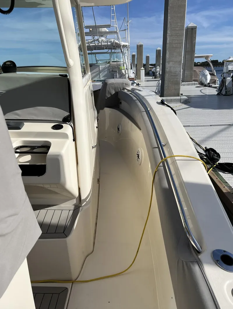 Slide: The Image of 2021 Scout 305 LXF boat docked at marina, featuring sleek design and modern amenities. - 3