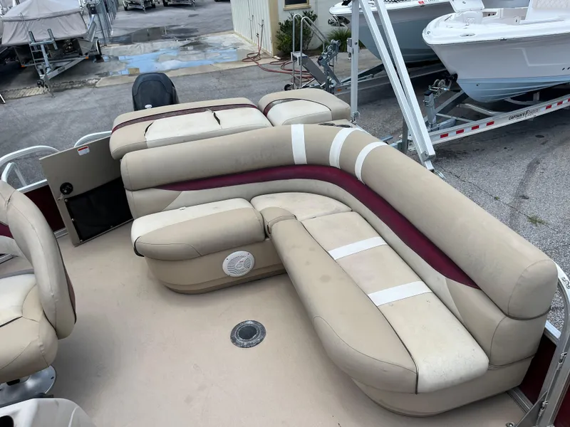 Slide: The Image of 2013 Sun Tracker Party Barge 22 DLX with beige and maroon seating on a trailer. - 7