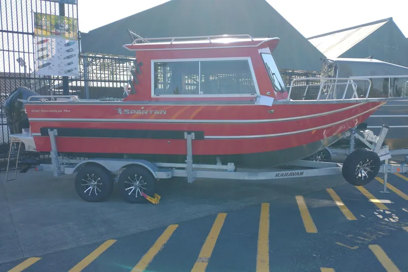 The Image of 2024 Spartan 220 Maximus Pro boat on trailer, red exterior, parked outdoors. - 0