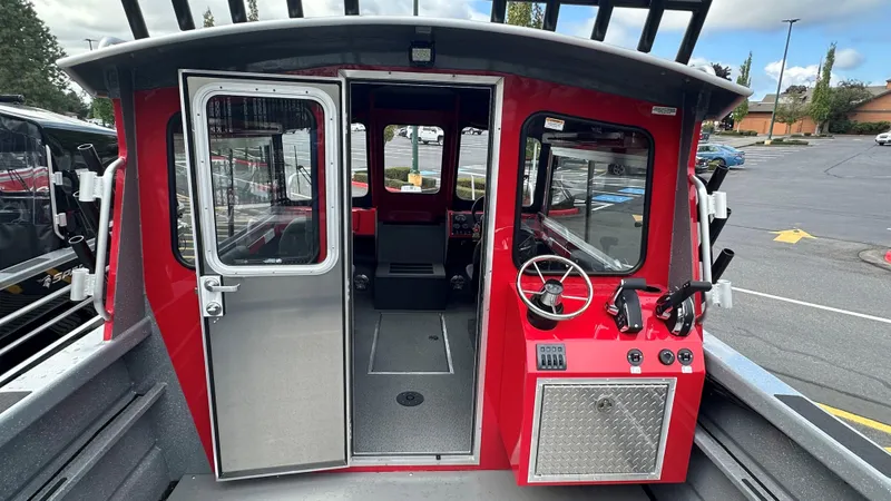 Slide: The Image of 2024 Spartan 220 Maximus Pro boat helm with steering wheel and controls. - 3