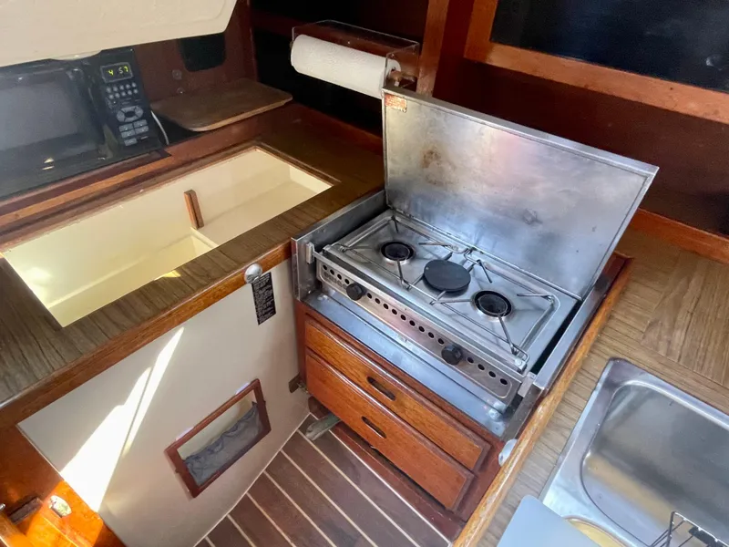 Slide: The Image of Interior of 1980 Catalina 38 sailboat with stove, sink, and wooden cabinetry. - 17