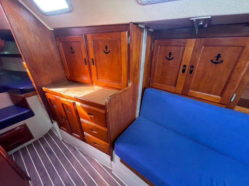 Slide: The Image of Interior of 1980 Catalina 38 sailboat with wooden cabinets and blue seating. - 19
