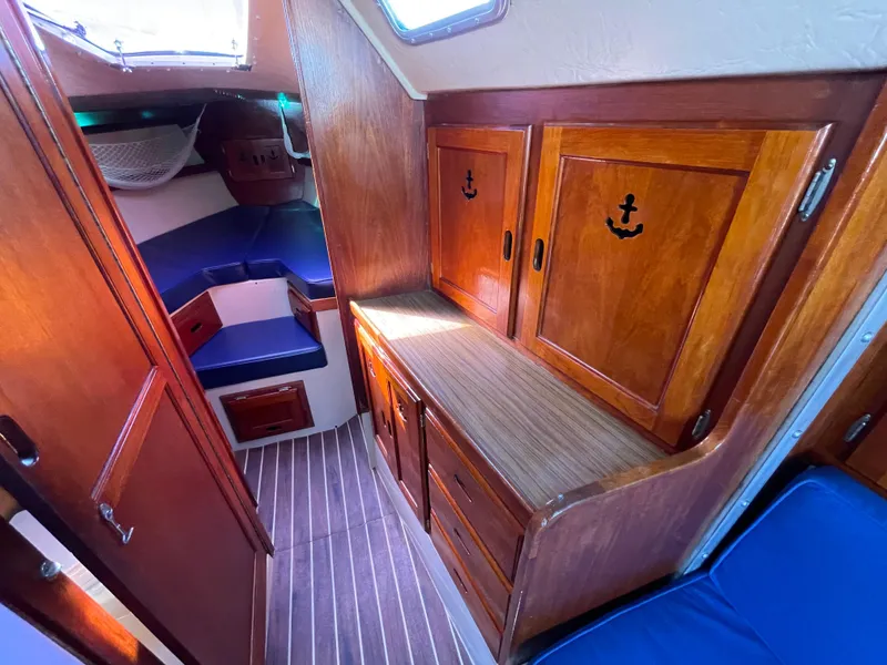 Slide: The Image of Interior of 1980 Catalina 38 sailboat with wooden cabinets and blue seating. - 20